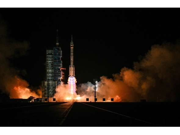 A Long March-2F carrier rocket, carrying the Shenzhou-21 spacecraft and a crew of three astronauts, lifts off from the Jiuquan Satellite Launch Centre in the Gobi desert, in northwest China on October 31, 2025. (Photo by Hector Retamal / AFP)