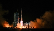 A Long March-2F carrier rocket, carrying the Shenzhou-21 spacecraft and a crew of three astronauts, lifts off from the Jiuquan Satellite Launch Centre in the Gobi desert, in northwest China on October 31, 2025. (Photo by Hector Retamal / AFP)