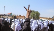 A Sudanese Student flashes the V-sign for victory as schools in the East Nile region of the capital gather during a protest against violations committed by the Rapid Support Forces (RSF) against the people of El- Fasher, in Khartoum on November 3, 2025. (Photo by Ebrahim Hamid / AFP)

