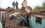 Afghan earthquake survivors search through the remains of a damaged house at a village in Tashqurghan, in the Khulm district of Samangan province on November 3, 2025. (Photo by Atif Aryan / AFP)