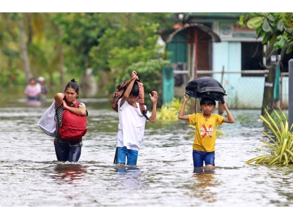 Residents evacuate from their flooded homes due to heavy rain brought by Typhoon Fung-wong in Remedios T. Romualdez. Photo by Erwin Mascarinas/ AFP