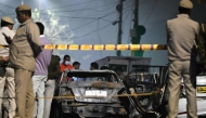 Security personnel stand beside charred vehicles at the blast site after an explosion near the Red Fort in the old quarters of Delhi on November 10, 2025. (Photo by Sajjad HUSSAIN / AFP)
