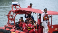 Malaysian rescuers approach a jetty after rescuing Rohingya migrant Iman Shorif (L), days after his boat carrying migrants from Myanmar capsized near the Malaysia-Thailand border, in Langkawi on November 11, 2025. (Photo by Hakim Mustapha / AFP)