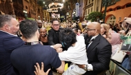 This picture by The Straits Times taken November 13, 2025 and provided on November 14 shows a man (C) accused of attacking pop star Ariana Grande being grabbed by security guards as co-star Cynthia Erivo (3rd L) reacts at the premiere of their film 