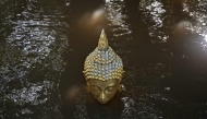 Floodwaters cover a Buddhastatue of at Wat Taku Buddhist temple in Bang Ban district in the central Thai province of Ayutthaya on November 14, 2025. (Photo by Lillian SUWANRUMPHA / AFP)