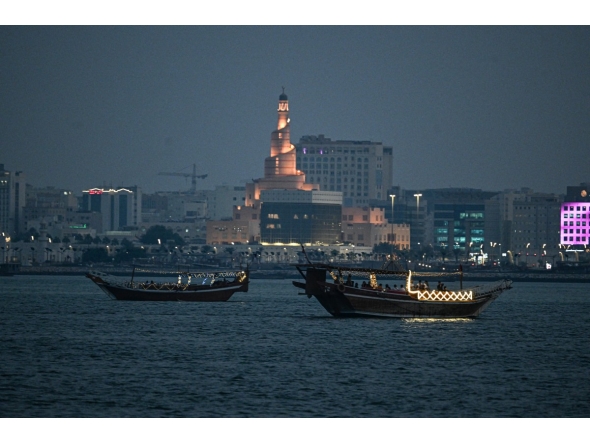 Tourists ride traditional boats along Doha Corniche. AFP file photo.