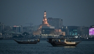 Tourists ride traditional boats along the corniche promenade in Doha on November 12, 2025. Photo by Mahmud HAMS / AFP
