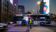 Vehicles drive past a traffic policeman in the Gwanghwamun district of Seoul on November 7, 2025. (Photo by ANTHONY WALLACE / AFP)