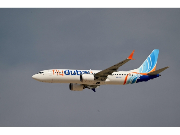 A Flydubai Boeing 737 MAX 8 performs a display flight at Al-Maktoum International Airport during the Dubai Airshow 2025 in Dubai on November 17, 2025. (Photo by Giuseppe CACACE / AFP)