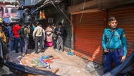 A police personnel stands guard near the rubble that fell from a damaged building following an earthquake in Old Dhaka on November 21, 2025. (Photo by Munir UZ ZAMAN / AFP)