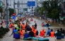 This photo taken on November 20, 2025 shows people wading through floodwaters in Nha Trang in Vietnam's coastal province of Khanh Hoa. (Photo by Duc Thao / AFP)