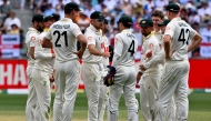 Australian players wait for the third umpire decision on England's Jamie Smith dismissal on day 2 of the first Ashes cricket Test match between Australia and England at Perth Stadium in Perth on November 22, 2025. (Photo by Saeed Khan / AFP) /