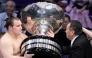 Ukrainian sumo wrestler Danylo Yavhusishyn, also known by his Japanese ring name Aonishiki Arata (L), receives the Prime Minister's Cup trophy after winning the Grand Sumo Tournament in Fukuoka on November 23, 2025. (Photo by JIJI PRESS / AFP) 