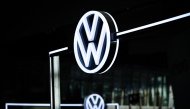 The illuminated VW Logo is pictured in the customer centre at the headquarters of German carmaker Volkswagen (VW) in Wolfsburg, central Germany, on November 21, 2025. (Photo by Ronny Hartmann / AFP)
