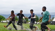 Children play football in a flooded field following rain in Jantho, Aceh province on November 24, 2025. (Photo by Chaideer Mahyuddin / AFP)