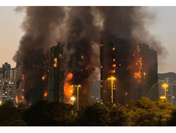 Thick smoke and flames rise as a major fire engulfs several apartment blocks at the Wang Fuk Court residential estate in Hong Kong's Tai Po district on November 26, 2025. (Photo by Yan ZHAO / AFP)