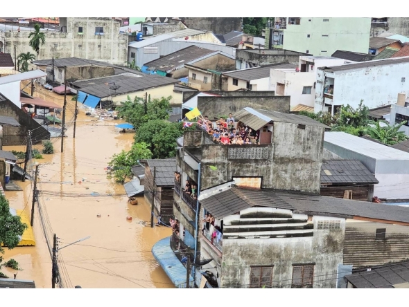 This handout photo taken and released by the Royal Thai Navy on November 26, 2025 shows people looking out from residential buildings surrounded by flood waters in Hat Yai. (Photo by Handout / Royal Thai Navy / AFP) 