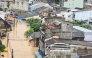 This handout photo taken and released by the Royal Thai Navy on November 26, 2025 shows people looking out from residential buildings surrounded by flood waters in Hat Yai. (Photo by Handout / Royal Thai Navy / AFP) 