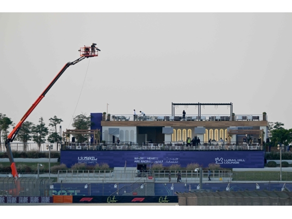 Workers prepare a stand at the Lusail International Circuit ahead of the Formula One Qatar Grand Prix in Lusail on November 27, 2025. (Photo by Mahmud Hams / AFP)