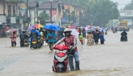 People wade through a flooded road after heavy rainfall in Kaduwela on the outskirts of Colombo on November 28, 2025. (Photo by Ishara S. KODIKARA / AFP)
