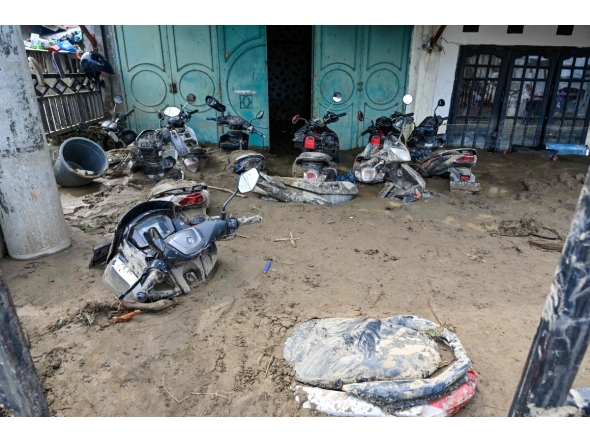 A general view shows motorcycles trapped in mud after the flash floods in Meureudu, Pidie Jaya district of Indonesia's Aceh province, on November 28, 2025. (Photo by Chaideer MAHYUDDIN / AFP)
