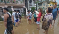 Residents stand in the mud as they wait to be evacuated from their flood-hit homes after Typhoon Kalmaegi hit Cebu City in the central Philippines on November 4. Photo by Alan Tangcawan / AFP