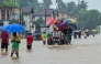 People move through a flooded road after heavy rainfall in Kaduwela on the outskirts of Colombo on November 28, 2025.  (Photo by Ishara S. Kodikara / AFP)