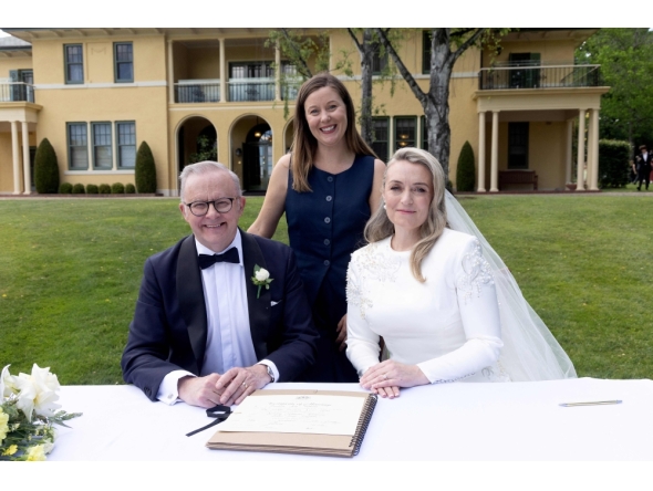 Australia Prime Minister Anthony Albanese (L) and his new wife Jodie Haydon (R) sign the marriage certificate with celebrant Bree during their wedding ceremony in Canberra on November 29, 2025. (Photo by Mike Bowers / AFP)