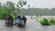 Motorists wade through a flooded street in Biyagama on the outskirts of Colombo on November 28, 2025. (Photo by Ishara S. KODIKARA / AFP)