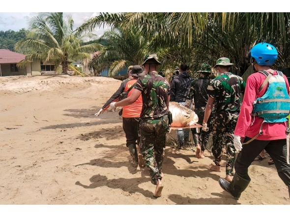 This handout image taken on November 30, 2025 and released on December 1, 2025 by Indonesia's National Search and Rescue Agency (Basarnas) shows military and rescue personnel carrying the body of a flood victim in Batangtoru, South Tapanuli, North Sumatra. (Photo by Handout / BASARNAS / AFP) 
