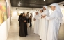 Officials and visitors view paintings on display at Katara during an exhibition held in connection with the FIFA Arab Cup Qatar 2025.   