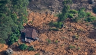 An aerial view shows a residential house lying in a shattered state at the site of a landslide in Nuwara Eliya on December 2, 2025. Photo by ISHARA S. KODIKARA / AFP