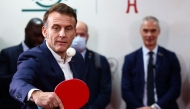 French President Emmanuel Macron plays table tennis during a meeting with Chinese and French table tennis players and students at Sichuan University in Chengdu, in southwestern China's Sichuan province on December 5, 2025. (Photo by Sarah Meyssonnier / POOL / AFP)