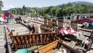 A flood victim restores his belongings in the aftermath of Cyclone Ditwah, along railway tracks in Kandy on December 6, 2025. (Photo by AFP)