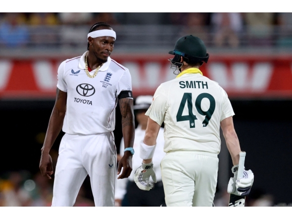 Australia's captain Steve Smith (R) reacts with England's Jofra Archer on day four of the second Ashes cricket Test match between Australia and England on December 7, 2025. (Photo by David Gray / AFP) 