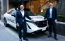 Nissan Motor CEO Ivan Espinosa (L) and Wayve Technologies CEO Alex Kendall (R) pose with a vehicle equipped with the ProPILOT next-generation driver assistance technology system after their signing ceremony in Tokyo on December 10, 2025. (Photo by Kazuhiro Nogi/ AFP)