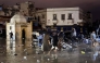 People wade through a square after a flash flood in Safi on December 14, 2025. Flash-flooding caused by sudden, heavy rain killed at least 21 people in the Moroccan coastal town of Safi on December 14, local authorities said. (Photo by AFP)