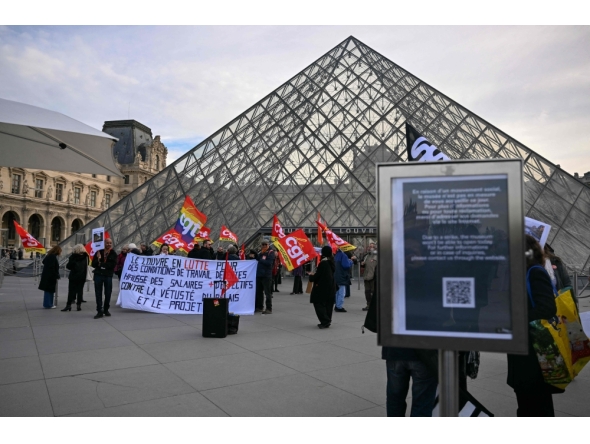 Members of the French CGT union protest outside the entrance to the Louvre Museum as workers voted to go on strike in Paris on December 15, 2025. (Photo by Blanca Cruz / AFP)