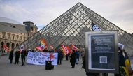 Members of the French CGT union protest outside the entrance to the Louvre Museum as workers voted to go on strike in Paris on December 15, 2025. (Photo by Blanca Cruz / AFP)
