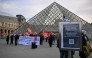Members of the French CGT union protest outside the entrance to the Louvre Museum as workers voted to go on strike in Paris on December 15, 2025. (Photo by Blanca Cruz / AFP)