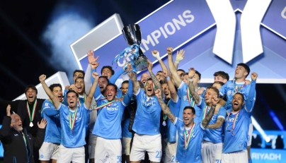Napoli’s Giovanni Di Lorenzo lifts the trophy on the podium as team celebrates the triumph. 
