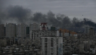 This photograph taken on December 27, 2025 shows smoke rising above residential buildings following Russian drones and missiles attack, in Kyiv, amid the Russian invasion in Ukraine. Photo by AFP