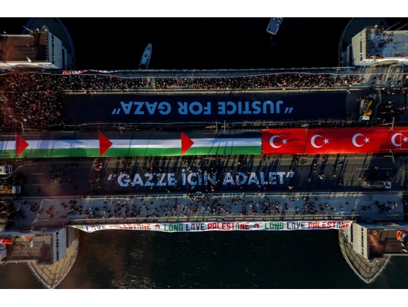 This aerial picture shows thousands of people demonstrating their solidarity with the Palestinian people at the Galata Bridge in Istanbul on January 1, 2026. (Photo by Yasin AKGUL / AFP)
