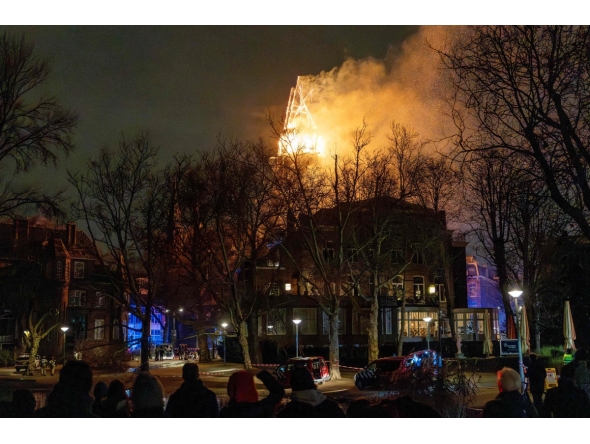People look at the tower of the Vondelkerk church on fire during New Year's Eve, in Amsterdam on January 1, 2026. (Photo by Laurens Niezen / ANP / AFP)