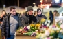 Mourners gather in front of flowers and candles laid near the site where a fire ripped through a crowded establishment during New Year's Eve celebrations in the Alpine ski resort town of Crans-Montana on January 1, 2026. Photo by MAXIME SCHMID / AFP