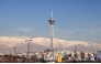 The Milad Tower is backdropped by the snow-covered Alborz Mountains, north of the capital Tehran on December 31, 2025. (Photo by Atta Kenare / AFP)
