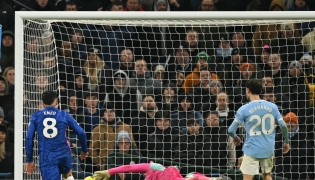 Manchester City's Italian goalkeeper #25 Gianluigi Donnarumma makes a save as Chelsea's Argentinian midfielder #08 Enzo Fernandez prepares to score during the English Premier League football match between Manchester City and Chelsea at the Etihad Stadium in Manchester, north west England, on January 4, 2026. (Photo by Oli SCARFF / AFP)