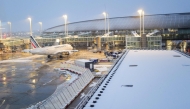 (FILES) This photograph shows an Air France aircraft with snow on the tarmac at the Roissy-Charles de Gaulle airport in Roissy-en-France, in the northern outskirts of Paris, on November 21, 2024. (Photo by Valery HACHE / AFP)