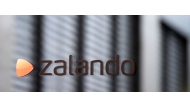 The logo of German shoes and clothing retailer Zalando is pictured at the office door in Berlin September 30, 2014. German online fashion retailer Zalando said on January 8, 2026 that it would close a distribution centre in the eastern city of Erfurt and lay off 2,700 employees to restructure its European logistics network. (Photo by Tobias Schwarz / AFP)