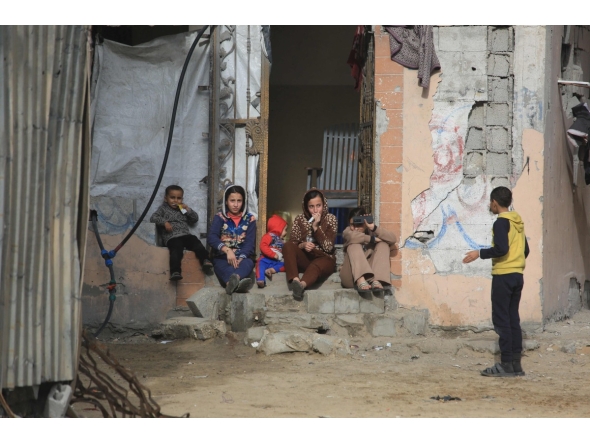 Children sit on doorstep of a damaged building in Jabalia, in the northern Gaza Strip, on January 10, 2026. (Photo by Bashar Taleb / AFP)
